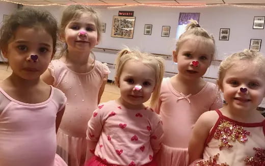 a group of girls wearing pink and white dresses