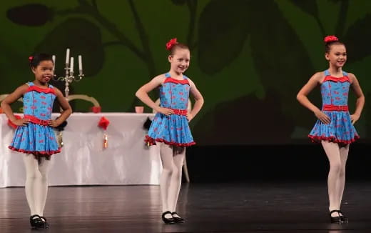 a group of girls in dresses on a stage