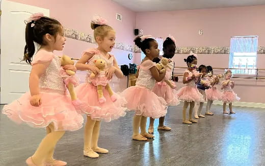 a group of girls in dresses dancing