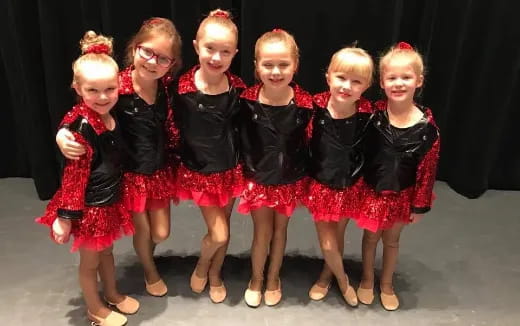 a group of girls in red and black dresses