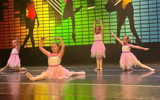 a group of girls dancing on a stage