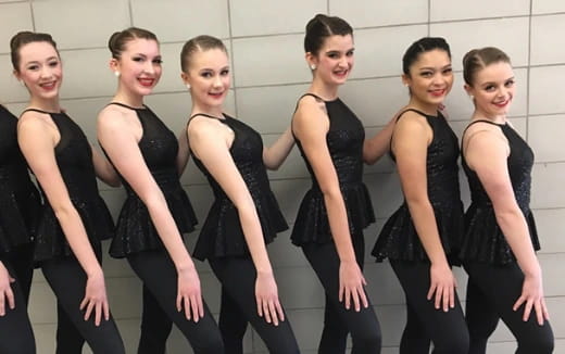 a group of women in black dresses