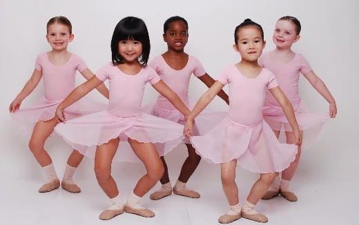 a group of girls in pink dresses