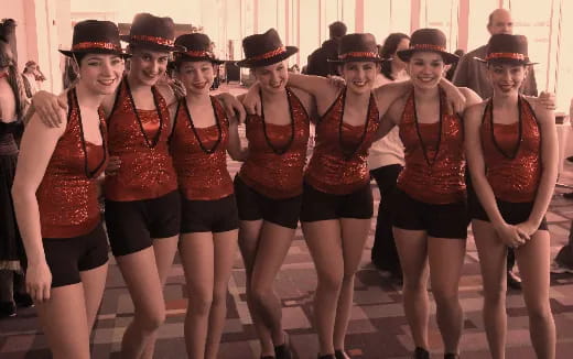 a group of women wearing hats and running