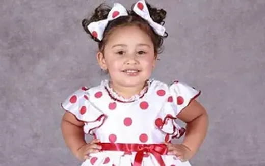 a baby girl wearing a pink dress