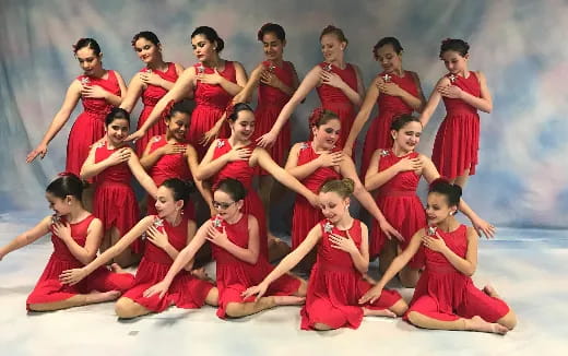 a group of women in red dresses