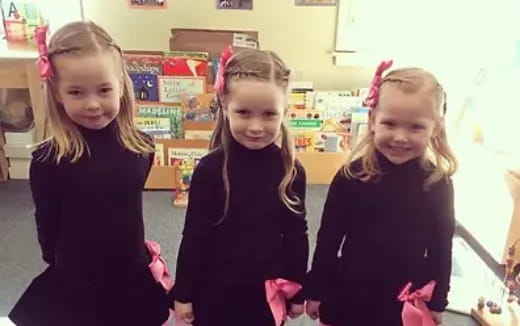 a group of girls wearing black dresses