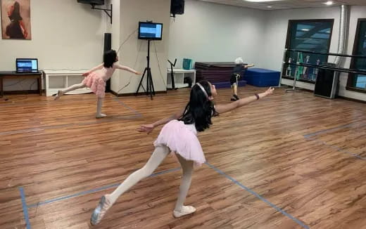 a group of girls dancing on a wood floor in a room