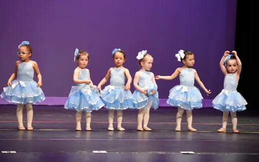 a group of girls in blue dresses