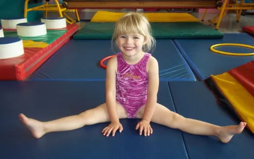 a girl sitting on a mat