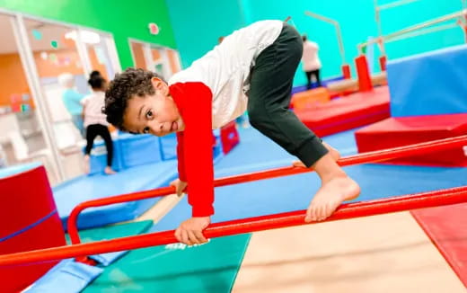 a boy doing a plank on a red mat