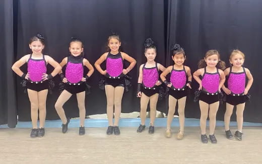 a group of girls in purple and black leotards