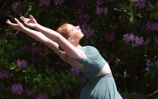 a person in a dress surrounded by purple flowers