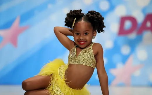 a little girl in a yellow dress