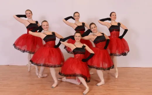 a group of women in red dresses