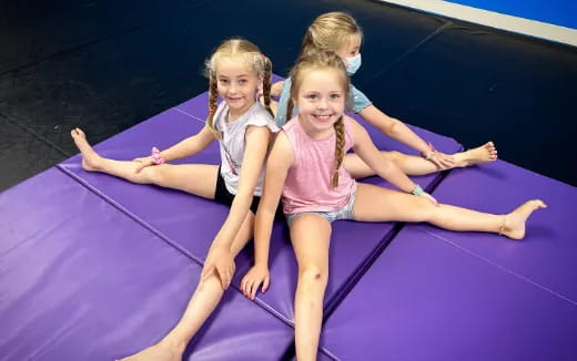 a group of girls on a purple mat