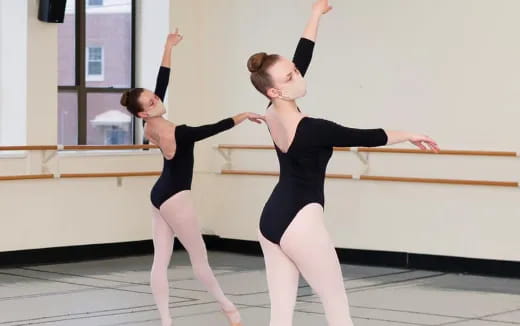 two women in black ballet outfits
