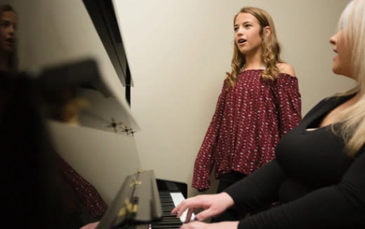 a woman playing a piano