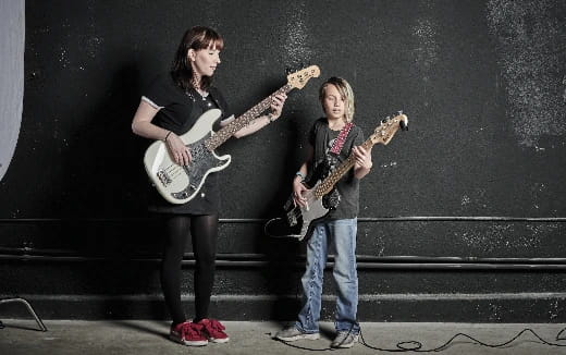 two people holding guitars