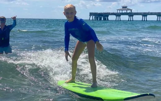 a boy on a surfboard in the ocean