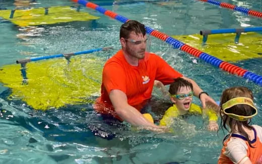 a man and kids in a pool