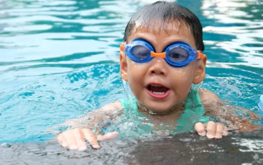 a baby wearing goggles in a pool