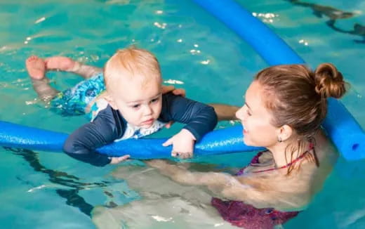 a person and a baby in a pool