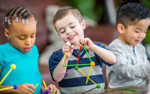 a few young children playing with colored pencils