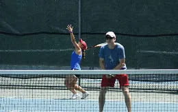 a woman hitting a ball with a tennis racket