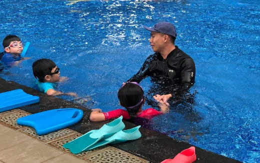 a person and a group of children in a pool