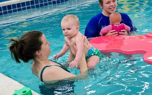 a person and a baby in a pool