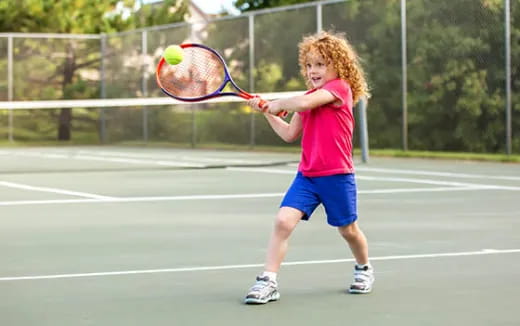 a young girl playing tennis