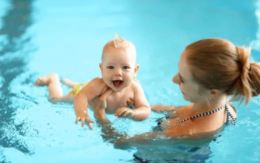 a person and a baby in a pool