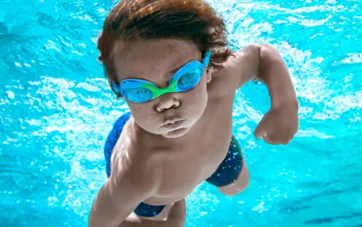 a boy wearing goggles and swimming