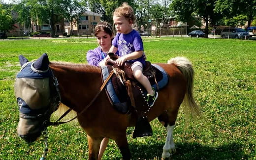 a couple of children riding horses