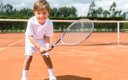 a boy holding a tennis racket