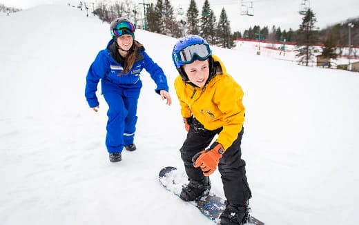 a couple of people stand on snowboards