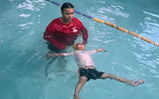 a man holding a woman in a pool