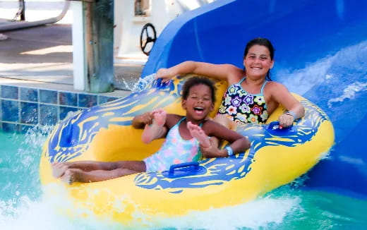 a person and a boy on a floating float in a pool