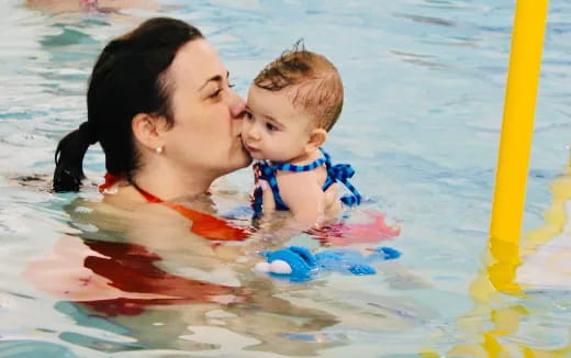 a person and a baby in a pool