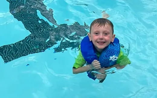 a boy in a pool with a shark