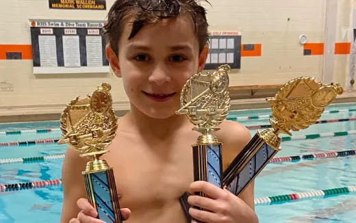 a boy holding trophies