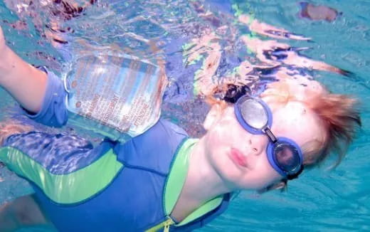 a person wearing goggles and swimming underwater