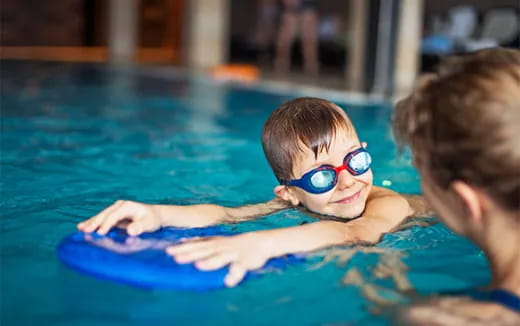 a boy in a pool wearing goggles