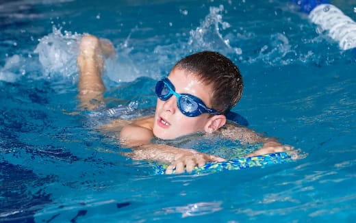 a boy swimming in a pool