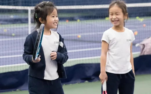 girls holding tennis rackets