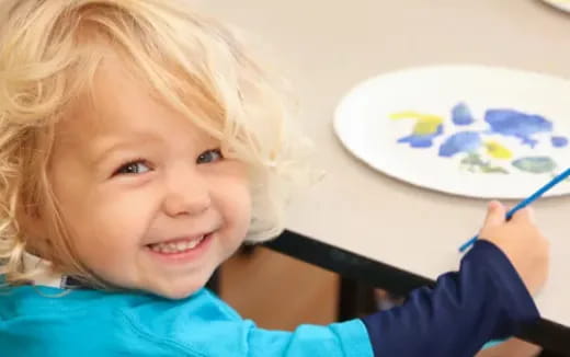 a child painting on a white board