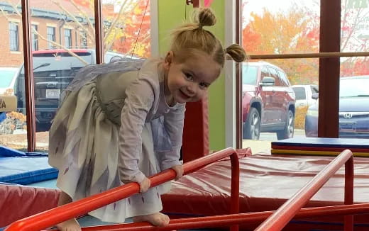 a girl sitting on a red railing
