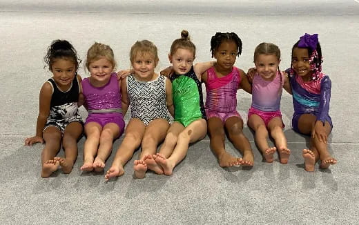 a group of children sitting on the beach