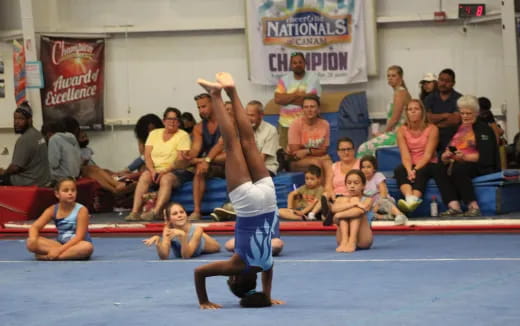 a person doing a handstand in front of a crowd